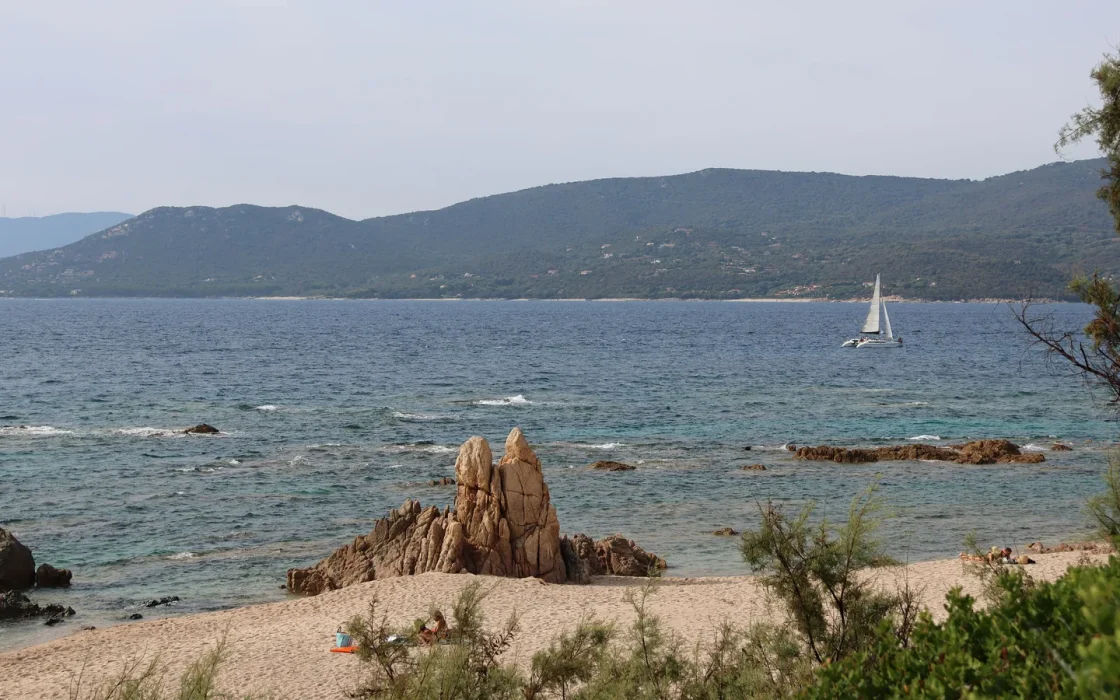 Voilier longeant la côte rocheuse de Corse