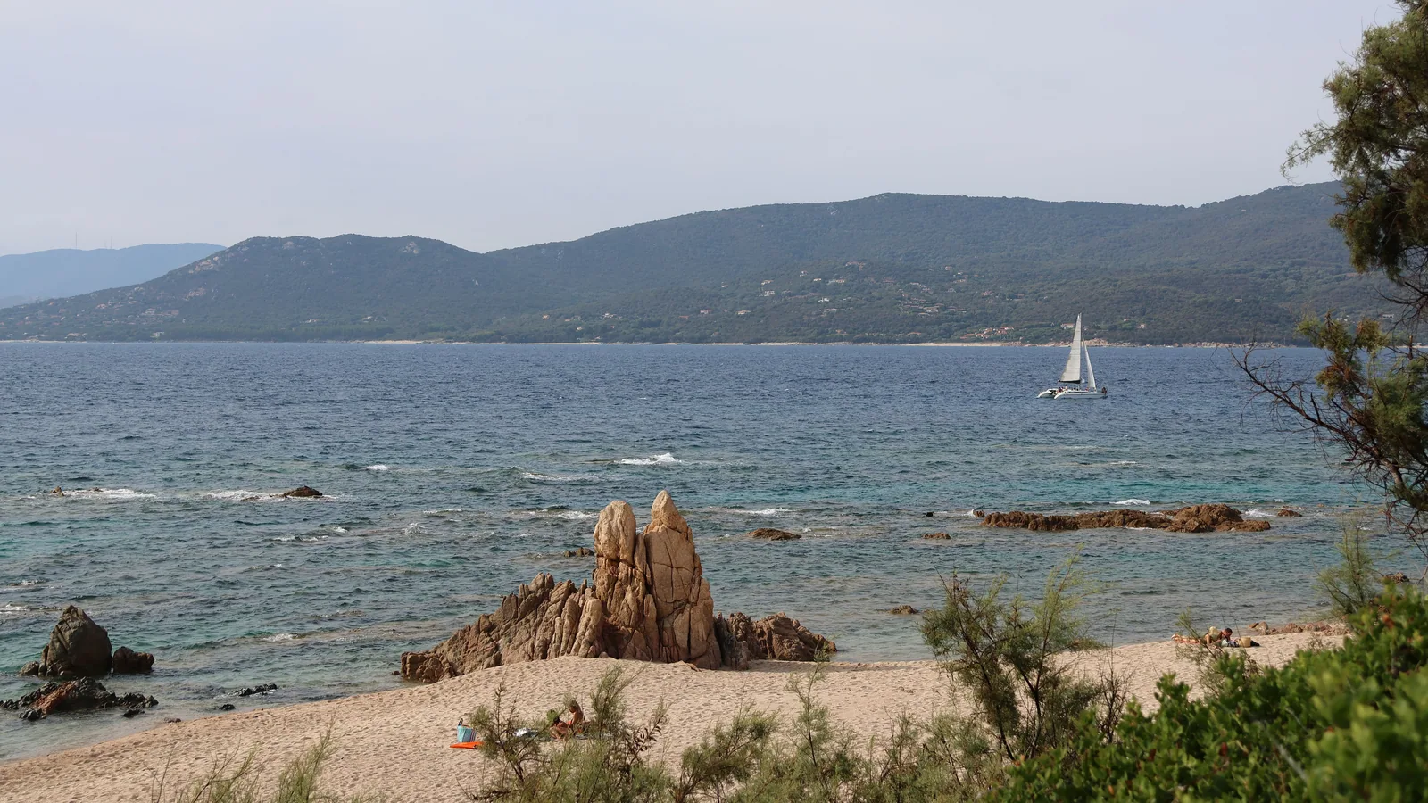 Voilier longeant la côte rocheuse de Corse